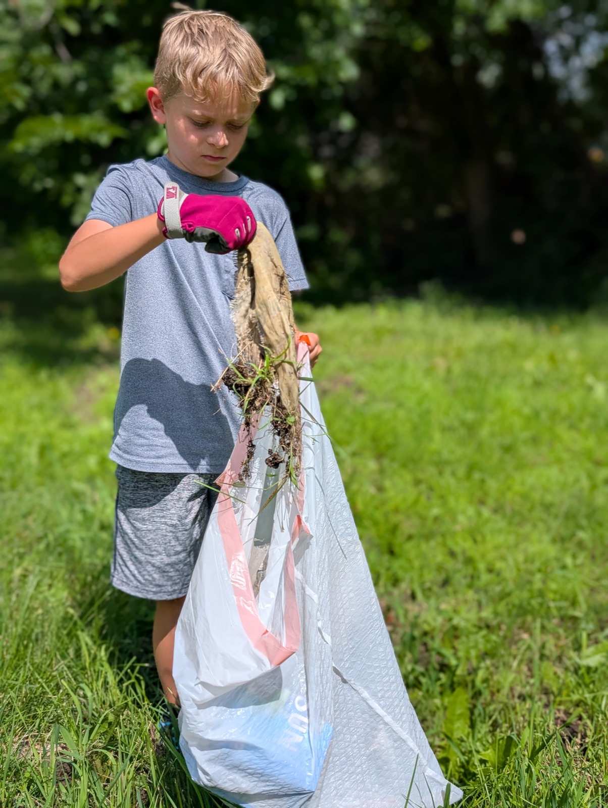 Malachi picking up trash in the neighborhood